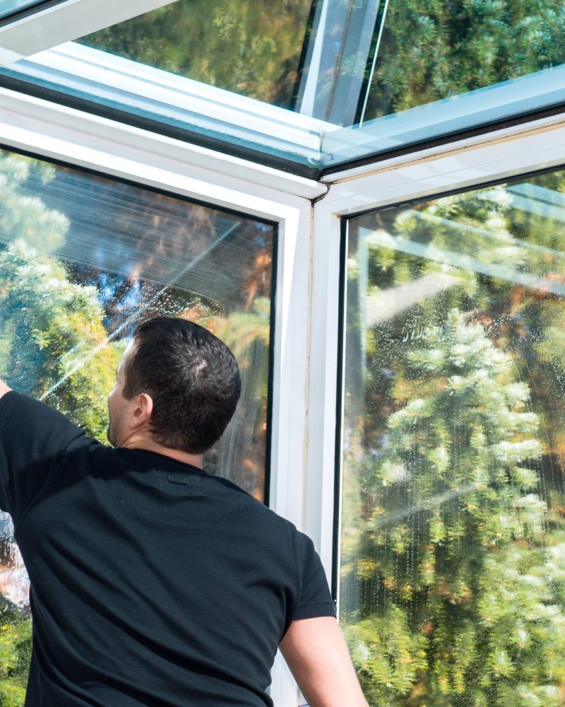 Man cleaning conservatory windows